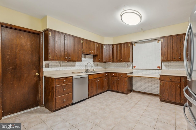 kitchen featuring decorative backsplash, stainless steel appliances, and sink