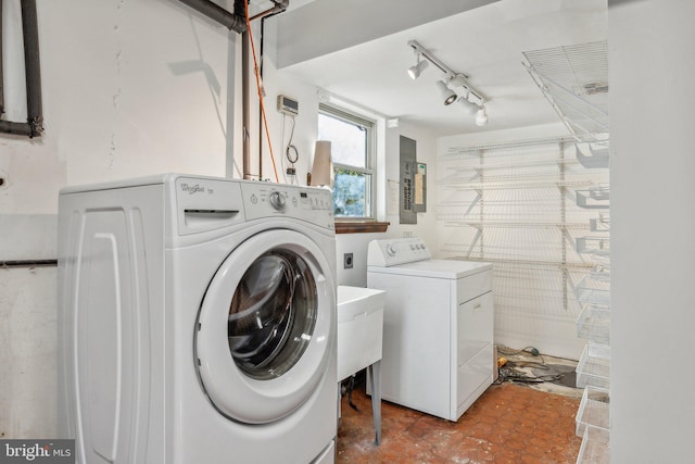 washroom with electric panel, rail lighting, and washer and clothes dryer