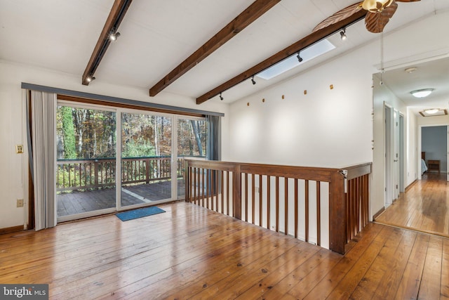 hall featuring light hardwood / wood-style floors and lofted ceiling with skylight