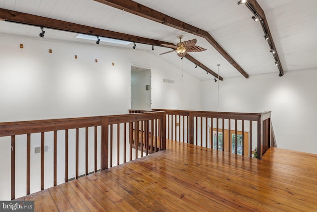 unfurnished room featuring lofted ceiling with beams, hardwood / wood-style flooring, and ceiling fan