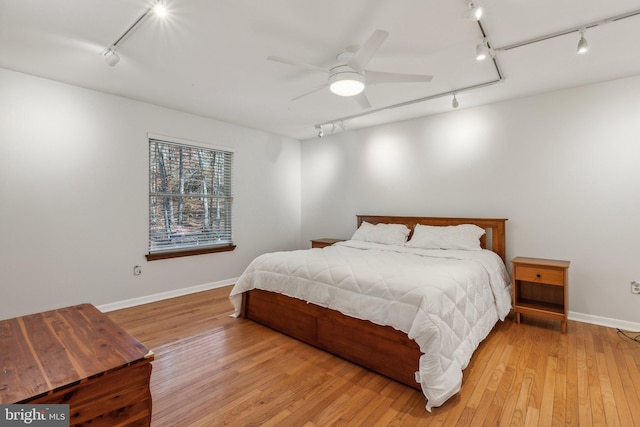 bedroom featuring ceiling fan, track lighting, and light hardwood / wood-style flooring