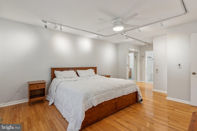 bedroom with track lighting, light hardwood / wood-style flooring, and ceiling fan