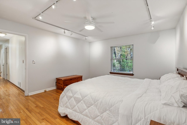 bedroom with light wood-type flooring, ceiling fan, and rail lighting