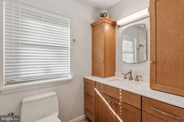 bathroom featuring a wealth of natural light, vanity, and toilet