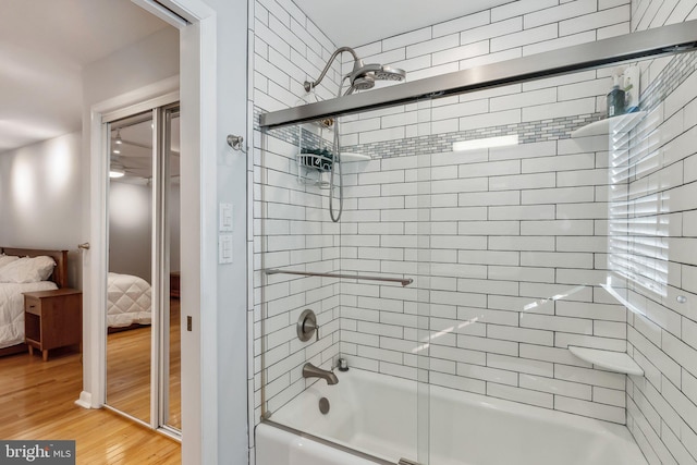 bathroom featuring hardwood / wood-style floors and combined bath / shower with glass door