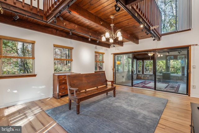 sitting room featuring an inviting chandelier, wood ceiling, hardwood / wood-style floors, and beam ceiling