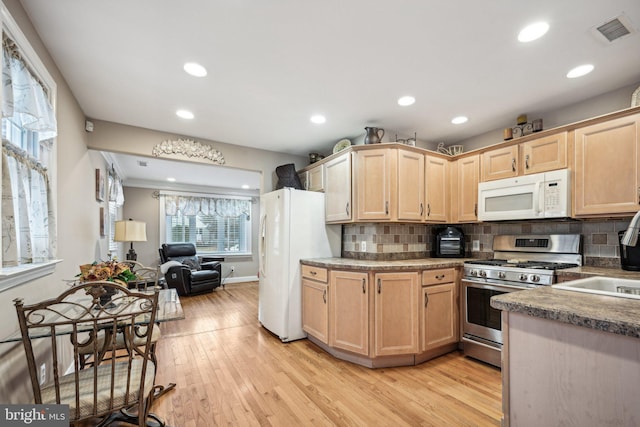 kitchen with light hardwood / wood-style floors, decorative backsplash, light brown cabinetry, and white appliances