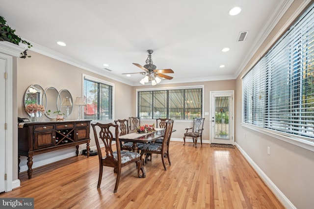 dining space with ornamental molding, a healthy amount of sunlight, and light wood-type flooring