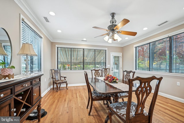 dining room featuring light hardwood / wood-style flooring, ornamental molding, and a healthy amount of sunlight