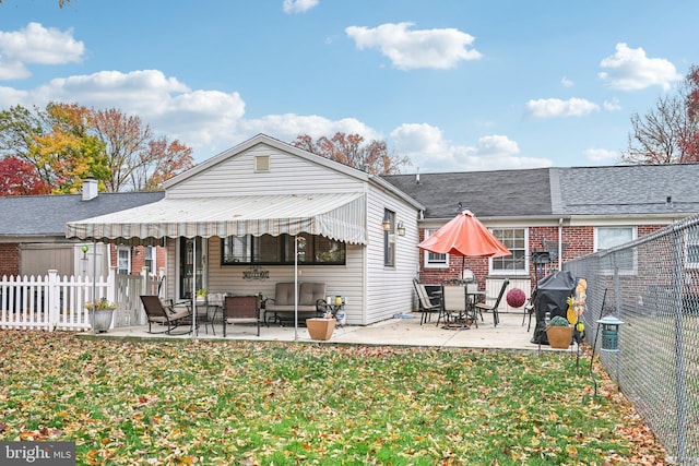 back of house featuring a patio and a lawn