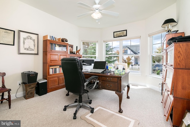 carpeted office space featuring ceiling fan