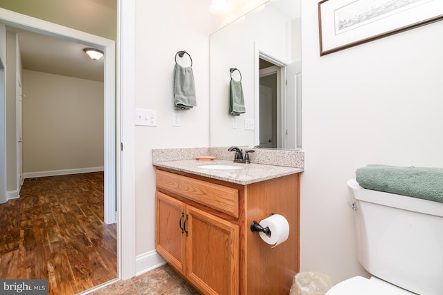 bathroom with vanity, wood-type flooring, and toilet