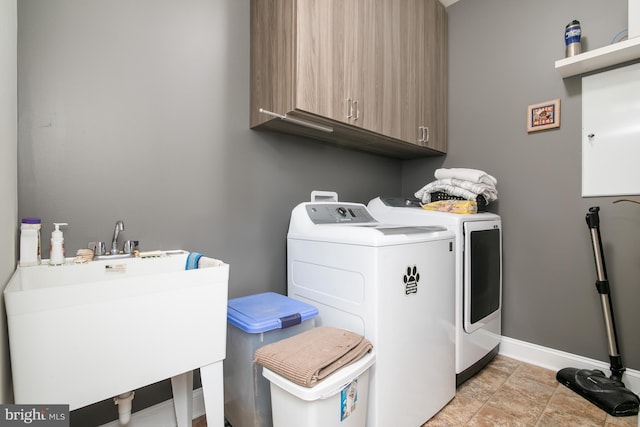 laundry area with cabinets, washer and dryer, sink, and light tile patterned floors