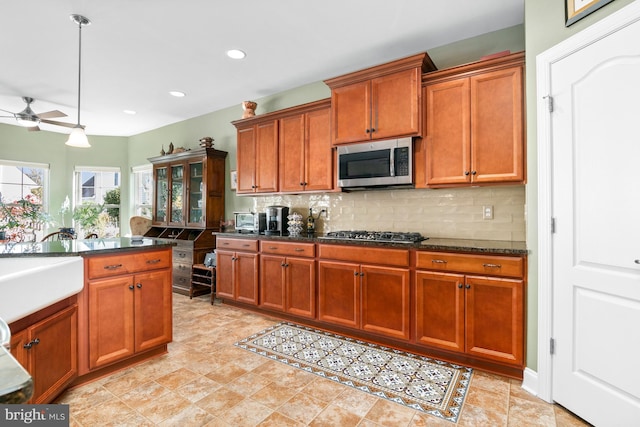 kitchen with sink, pendant lighting, tasteful backsplash, appliances with stainless steel finishes, and ceiling fan