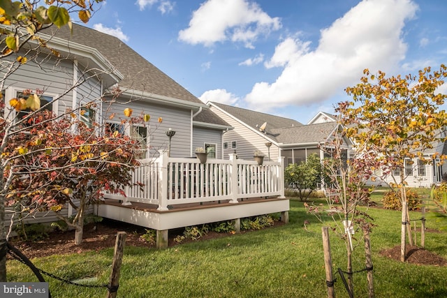 back of house with a wooden deck and a lawn