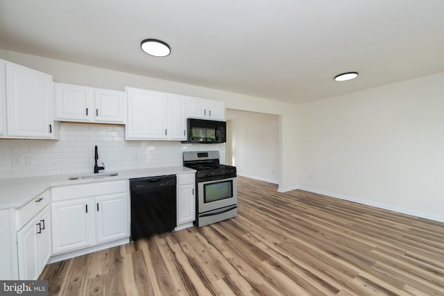 kitchen featuring black appliances, white cabinetry, sink, and light hardwood / wood-style flooring