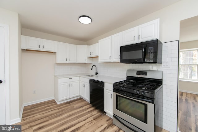 kitchen featuring black appliances, white cabinetry, decorative backsplash, sink, and light hardwood / wood-style floors