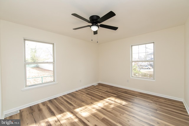 spare room with ceiling fan and wood-type flooring