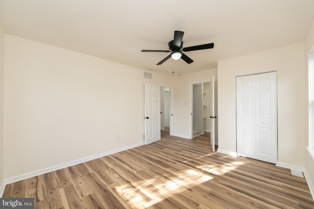 unfurnished bedroom featuring light hardwood / wood-style floors, ceiling fan, and a closet