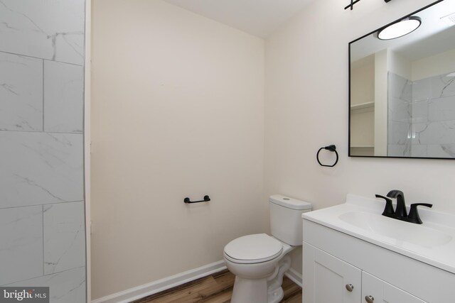 bathroom with wood-type flooring, toilet, and vanity