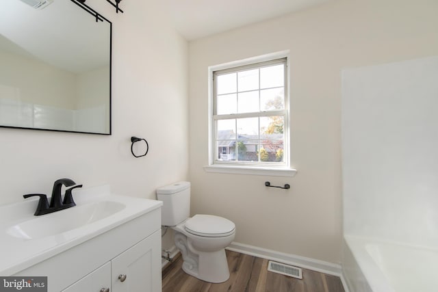 bathroom with vanity, hardwood / wood-style flooring, and toilet