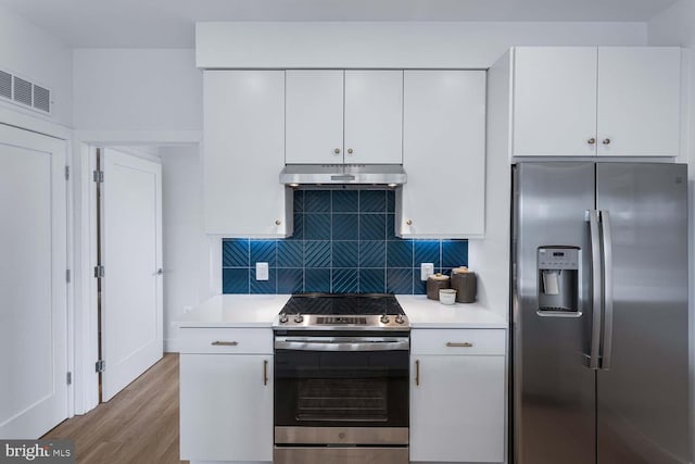 kitchen featuring white cabinets, stainless steel appliances, light wood-type flooring, and tasteful backsplash