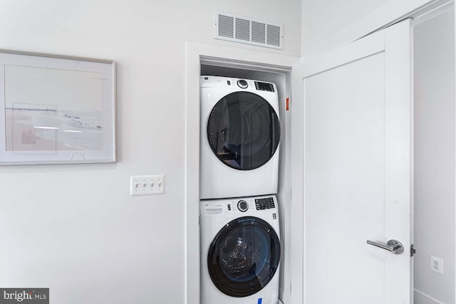 clothes washing area with stacked washer and clothes dryer