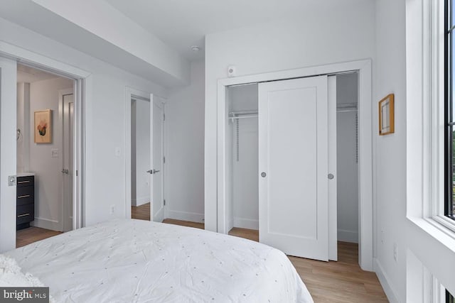 bedroom with light hardwood / wood-style flooring and a closet