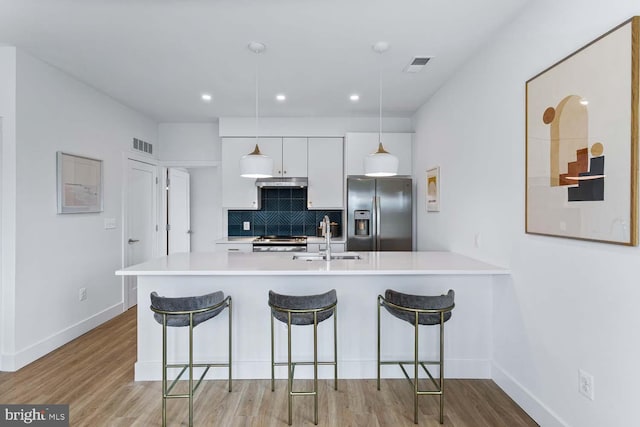 kitchen with white cabinetry, appliances with stainless steel finishes, sink, and light wood-type flooring