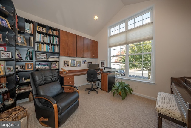 carpeted home office with vaulted ceiling