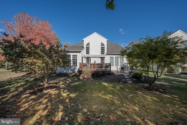 rear view of house featuring a yard and a wooden deck