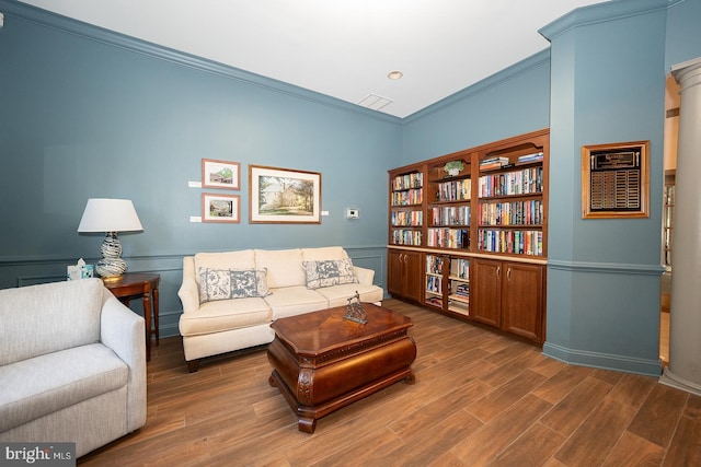 living room featuring dark hardwood / wood-style floors, decorative columns, and ornamental molding