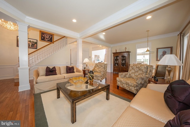 living room featuring hardwood / wood-style floors, ornamental molding, and decorative columns