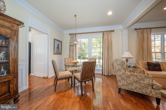 dining room with hardwood / wood-style floors, a wealth of natural light, and ornamental molding