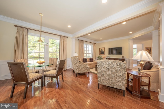 dining space featuring ornamental molding, light hardwood / wood-style flooring, and ornate columns