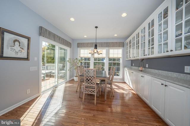 dining room featuring a wealth of natural light, hardwood / wood-style floors, and a notable chandelier