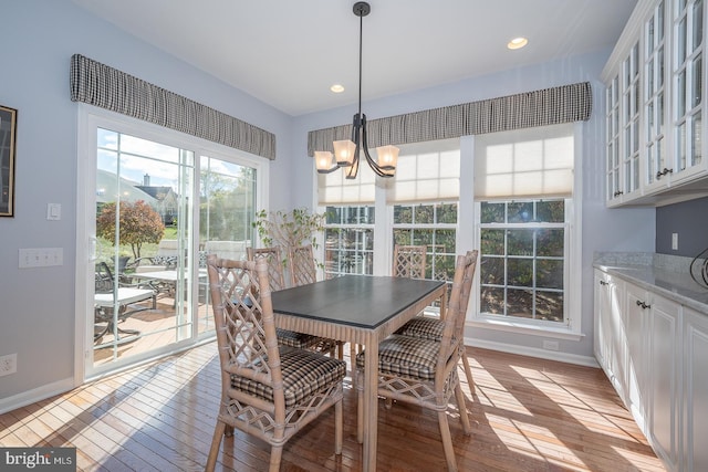 dining room with light wood-type flooring and a notable chandelier