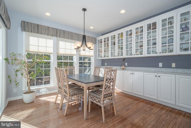 dining room with light hardwood / wood-style floors and a notable chandelier