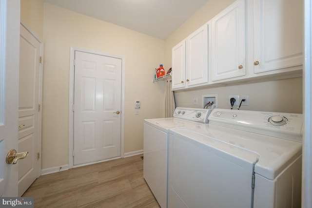 laundry area with cabinets, separate washer and dryer, and light hardwood / wood-style flooring