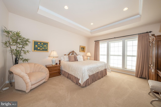 carpeted bedroom featuring a tray ceiling and ornamental molding