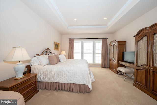 bedroom featuring a raised ceiling, light carpet, and ornamental molding