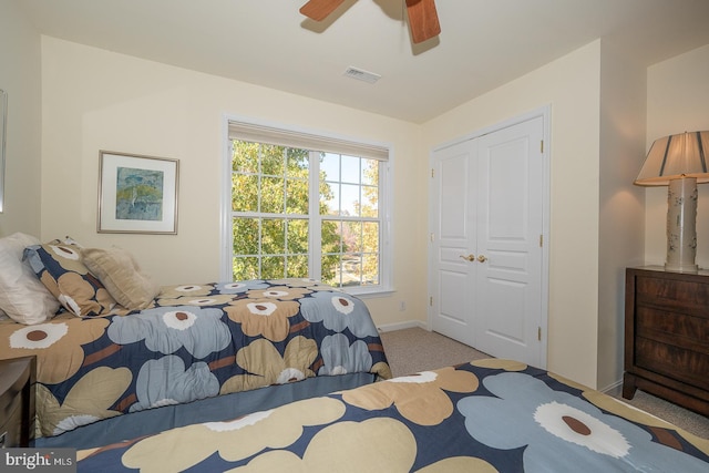 carpeted bedroom with ceiling fan and a closet