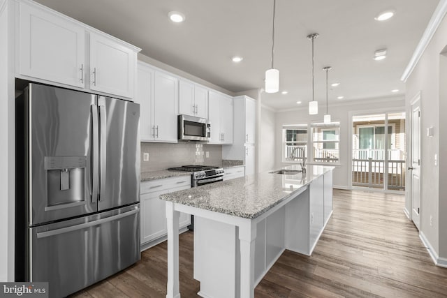 kitchen featuring dark hardwood / wood-style floors, stainless steel appliances, a center island with sink, light stone countertops, and white cabinets