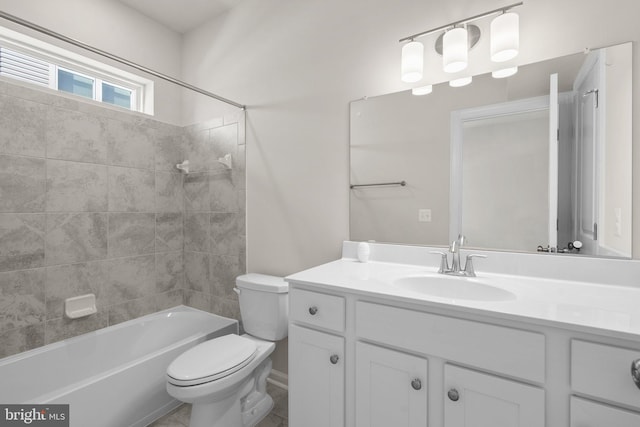 full bathroom with tiled shower / bath, vanity, and toilet