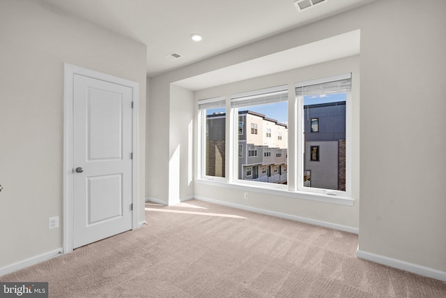 unfurnished room featuring light carpet