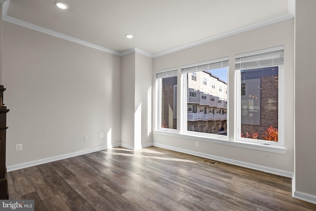 empty room with crown molding and wood-type flooring