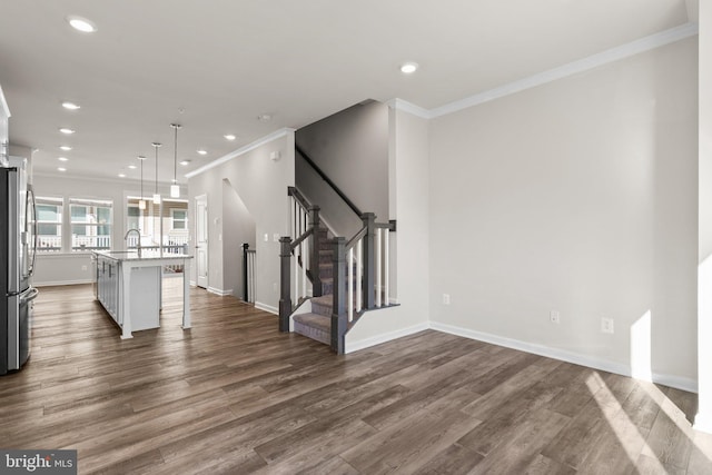 unfurnished living room featuring ornamental molding, sink, and dark hardwood / wood-style flooring