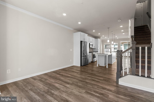 kitchen with a kitchen island, stainless steel appliances, pendant lighting, white cabinetry, and dark hardwood / wood-style flooring