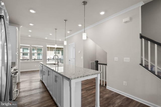 kitchen featuring white cabinetry, a kitchen island with sink, sink, and pendant lighting