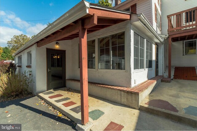 view of exterior entry with a patio